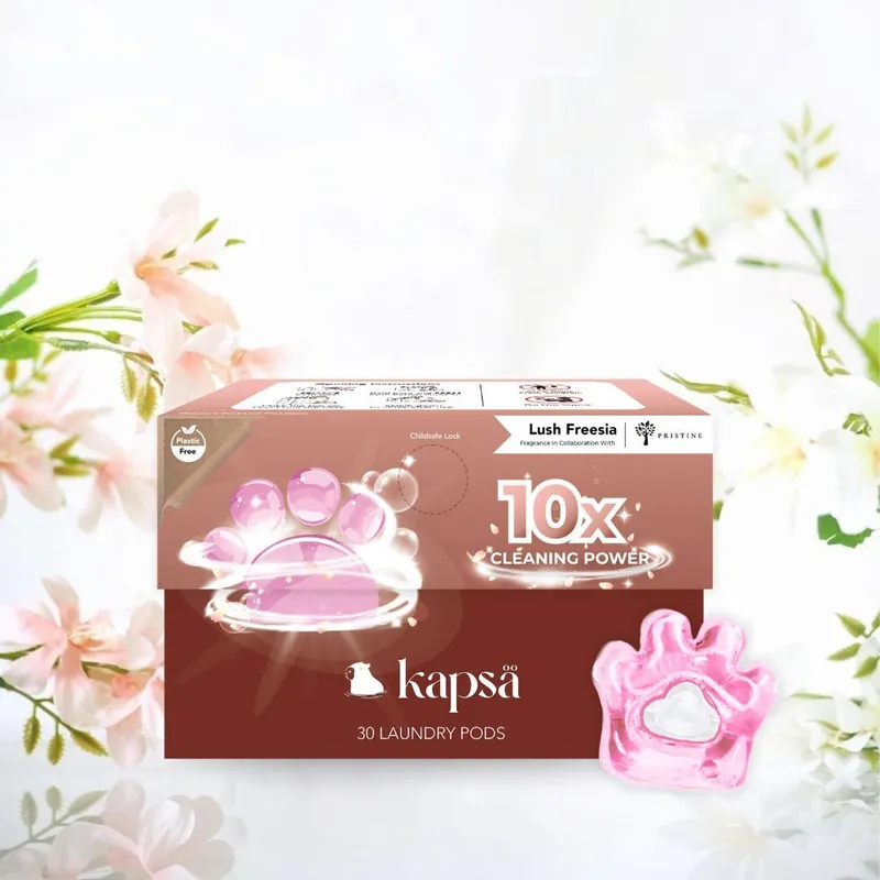 A box of Kapsä Lush Freesia laundry pods with a pink paw-shaped pod